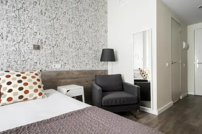 a bedroom with a bed and a chair at Residencia Universitaria Resa Roberto de Nobili in Sant Cugat del Vallès