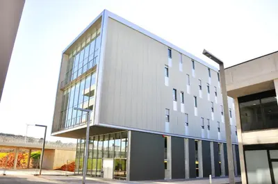 a large building with glass windows on a street at Residencia Universitaria Resa Roberto de Nobili in Sant Cugat del Vallès