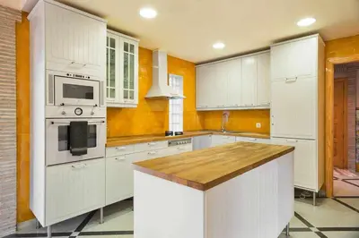 a kitchen with white cabinets and a stove top oven at Xalet de la Muntanya, El Bruc-Montserrat in El Bruc