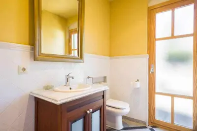 a bathroom with a sink and a toilet and a mirror at Xalet de la Muntanya, El Bruc-Montserrat in El Bruc
