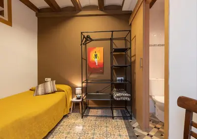 a bedroom with a yellow bed and a toilet at ApartEasy - Central Gracia Apartments in Barcelona