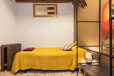 a bedroom with a bed with a yellow blanket at ApartEasy - Central Gracia Apartments in Barcelona