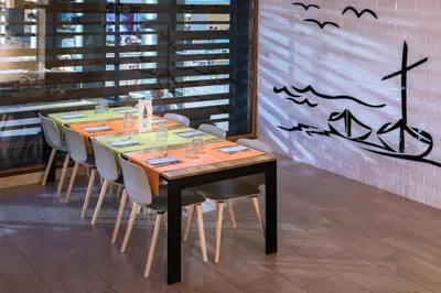 a dining room with a table with chairs and bats on the wall at Hotel President in Calella