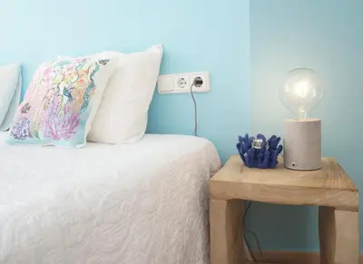 a bedroom with a bed and a table with a lamp at Love Sitges & Beach in Sitges