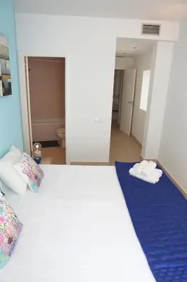 a bedroom with a white bed with towels on it at Love Sitges & Beach in Sitges