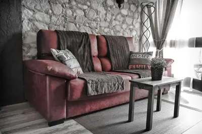 a red couch in a living room with a table at Cova Safaja in San Quírico Safaja