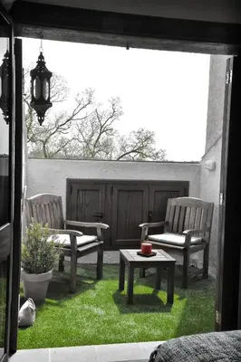 a patio with two chairs and a table on the grass at Cova Safaja in San Quírico Safaja