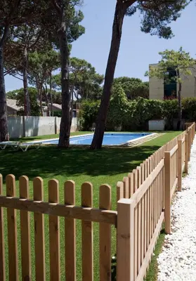 a wooden fence in front of a pool at SG Marina 54 Apartments in Castelldefels
