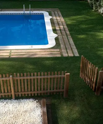 a wooden fence next to a swimming pool at SG Marina 54 Apartments in Castelldefels