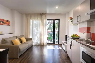 a living room with a couch and a kitchen at SG Marina 54 Apartments in Castelldefels