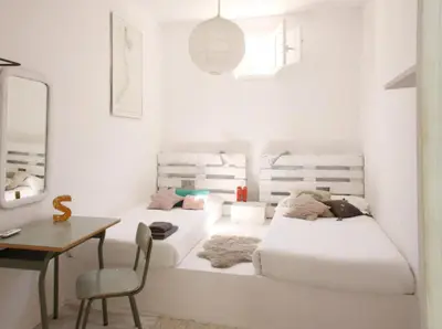 a white room with two beds and a table at Fridays Flats Villa Alba in Barcelona