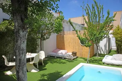 a backyard with a pool and a table and a tree at Fridays Flats Villa Alba in Barcelona