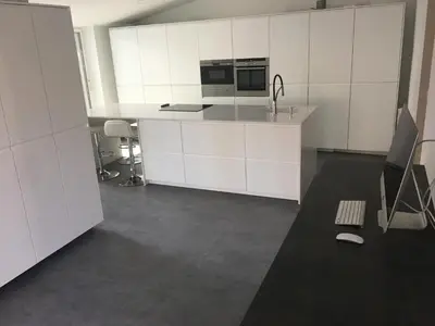 an empty kitchen with white cabinets and a sink at Villa Masnou Homelydays in El Carrer del Canonge