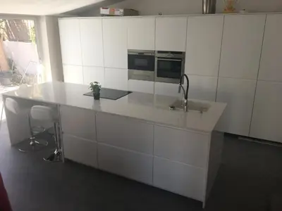 a white kitchen with a counter and a sink at Villa Masnou Homelydays in El Carrer del Canonge