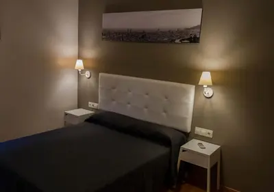 a bedroom with a bed with two night stands and two lamps at Hostal Sant Pau in Barcelona