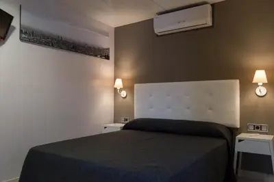 a bedroom with a bed and two night stands at Hostal Sant Pau in Barcelona