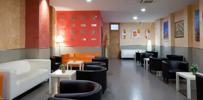 a waiting room with couches and tables and chairs at Hostal Barcelona in Barcelona