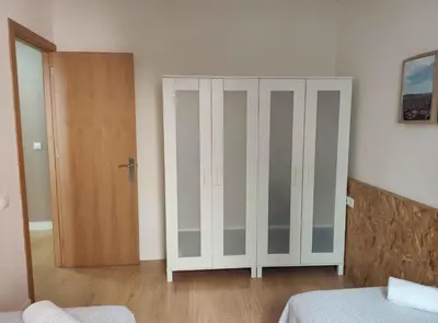 a bedroom with a white cabinet and a door at Diagonal Apartments in Barcelona