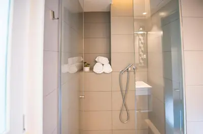 a bathroom with a shower with a glass door at Mosaic by Ona in Barcelona