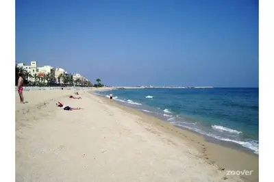 a beach with people laying on the sand and the ocean at Casa Premia in Premiá de Mar