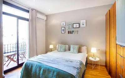 a bedroom with a large bed and a balcony at Apartments Barcelona & Home Deco Viladomat in Barcelona