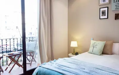 a bedroom with a bed and a balcony at Apartments Barcelona & Home Deco Viladomat in Barcelona