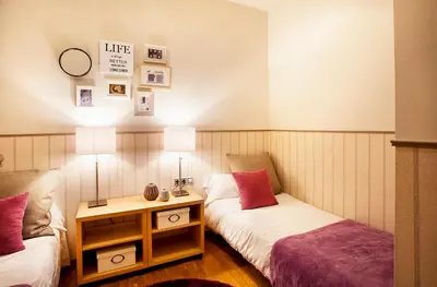 a room with two beds and a table with lamps at Apartments Barcelona & Home Deco Viladomat in Barcelona
