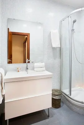 a white bathroom with a sink and a shower at Apartments Barcelona & Home Deco Viladomat in Barcelona