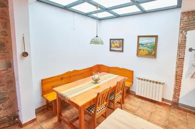 a dining room with a wooden table and chairs at Rincón de piedra BCN in Corró de Vall