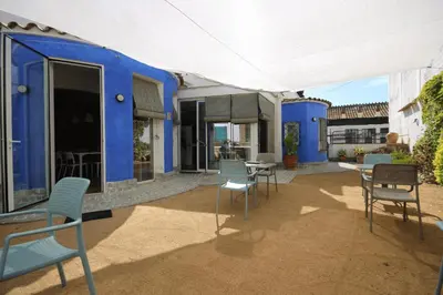 a blue house with chairs and a table in front of it at B&B Sant Pol - Adults Only in San Pol de Mar