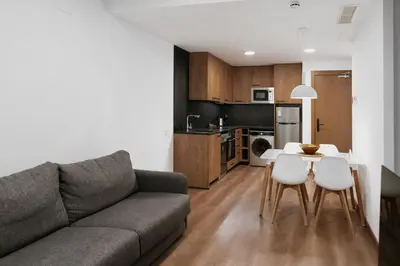 a living room with a couch and a table and chairs at Hotelet Casa Padró in Manresa