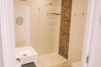 a bathroom with a shower and a white sink at Hotelet Casa Padró in Manresa