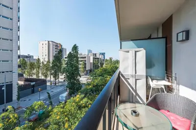 a balcony with a table and a view of a city at Jie Apartment in Sant Adria de Besos