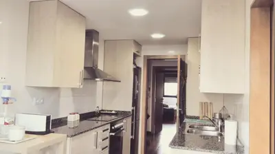 a kitchen with white cabinets and a sink at Jie Apartment in Sant Adria de Besos