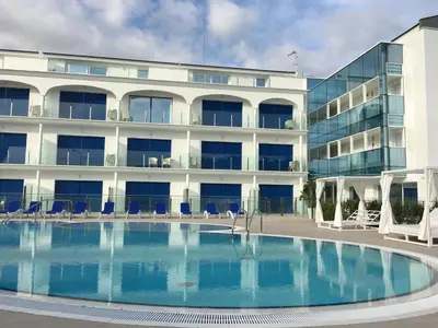 a large swimming pool in front of a building at Masd Mediterraneo Hotel Apartamentos Spa in Castelldefels