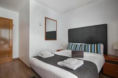 a bedroom with a bed with a laptop on it at Tendency Apartments Fira in Hospitalet de Llobregat