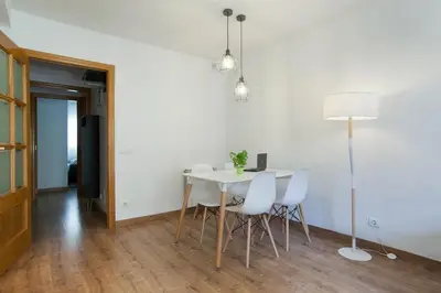 a dining room with a table and white chairs at Tendency Apartments Fira in Hospitalet de Llobregat