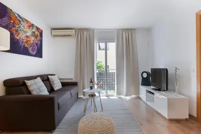 a living room with a couch and a tv at Tendency Apartments Fira in Hospitalet de Llobregat