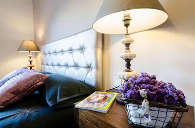a lamp on a table next to a bed with a book at Valencia Suite ArchsenseApartments in Barcelona