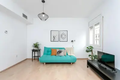 a living room with a blue couch and a tv at Centric Apartments Paseo de Gracia in Barcelona