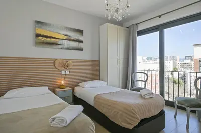 a hotel room with two beds and a balcony at Apartment Leonor in Barcelona