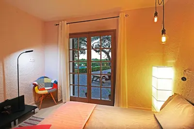 a bedroom with a bed and a sliding glass door at Casa Rural Els Pins in Sant Marçal