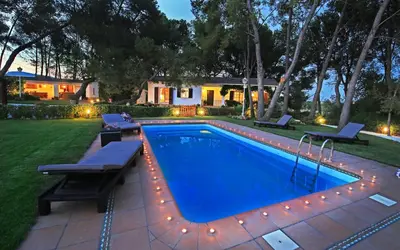 a swimming pool in a yard with lights and a house at Casa Rural Els Pins in Sant Marçal
