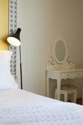 a bedroom with a bed and a dressing table with a mirror at Apart-Suites Hostemplo in Barcelona