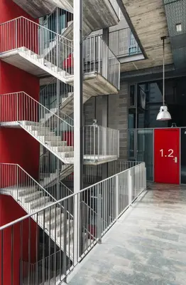 a metal staircase in a building with a red door at Barcelona Apartment Republica in Barcelona