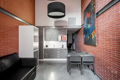 a dining room with a table and a brick wall at Barcelona Apartment Republica in Barcelona