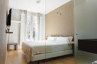a bedroom with a bed with a glass wall at Cosmopolitan Boutique Rambla in Barcelona