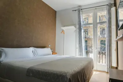 a bedroom with a bed and a large window at Cosmopolitan Boutique Rambla in Barcelona