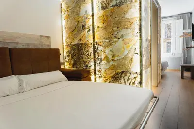 a bedroom with a bed and a stone wall at Cosmopolitan Boutique Rambla in Barcelona