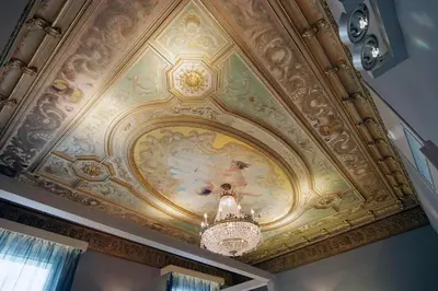a ceiling with a painting on it with a chandelier at Hotel Actual in Barcelona